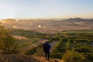 Wanderer schaut auf Tal im Sonnenuntergang