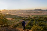 Wanderer schaut auf Tal im Sonnenuntergang